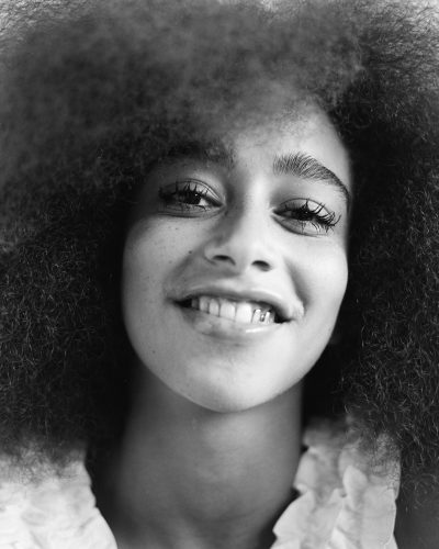 Portrait of smiling young woman with long afro